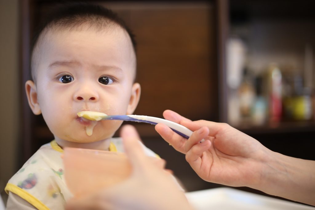 Mother feeding complementary food to baby